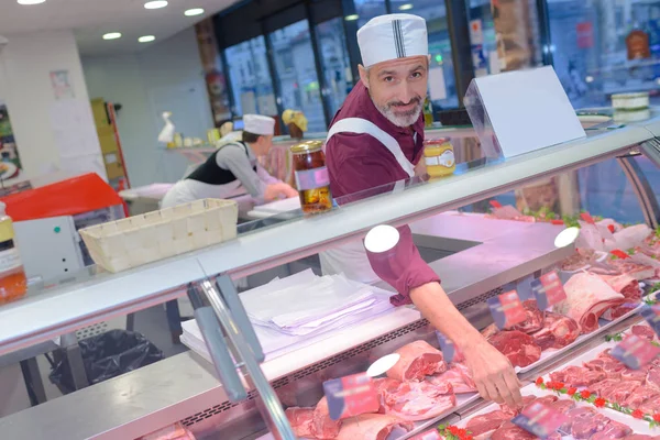 Slager leunend in de teller — Stockfoto