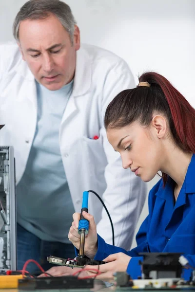 Ung kvinna student reparerar elektronik enhet — Stockfoto
