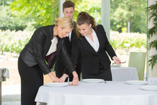 Waitress with manager setting the table in a restaurant — Stock Photo, Image