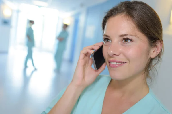 Cirurgião feminino usando telefone celular no hospital — Fotografia de Stock