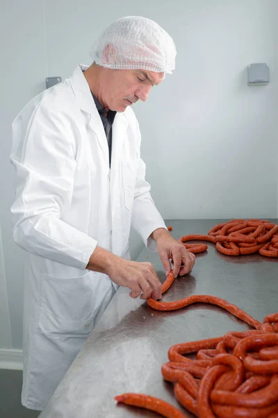 Butcher making sausages and sausage — Stock Photo, Image