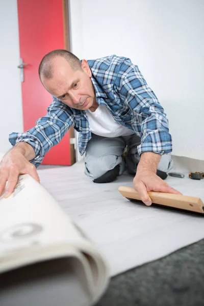 Handyman fitting carpet and man — Stock Photo, Image