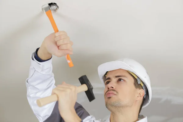 Homem está martelando o teto — Fotografia de Stock