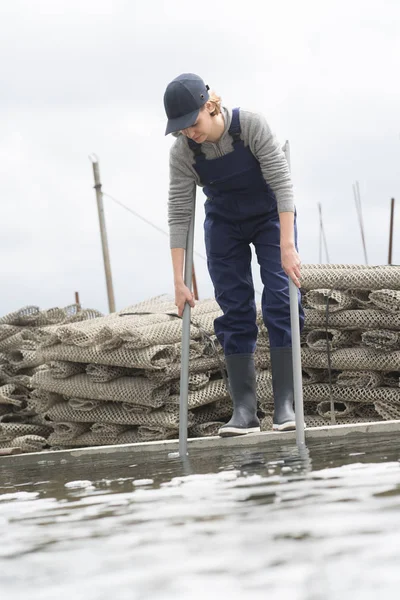 Kvinnlig arbetstagare och pool av oyster gård — Stockfoto