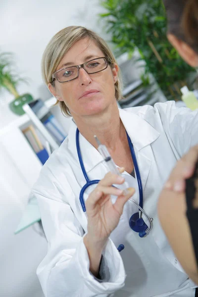 Médico femenino que sostiene la jeringa con inyección — Foto de Stock