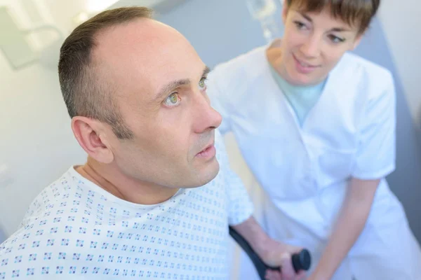 Médico femenino entregando muletas a paciente masculino — Foto de Stock