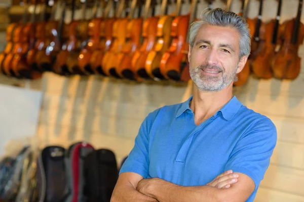 Homem posando em uma loja de violino — Fotografia de Stock