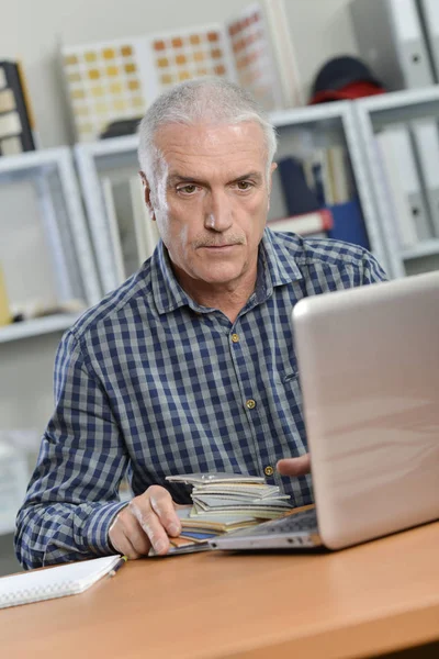 Senior kontorist vid sitt skrivbord — Stockfoto