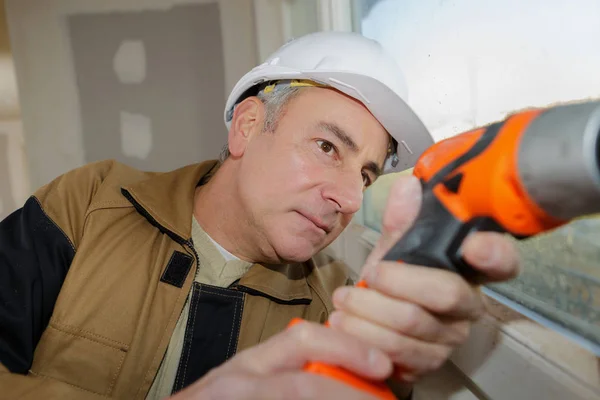 Bauarbeiter bohrt eine Mauer — Stockfoto