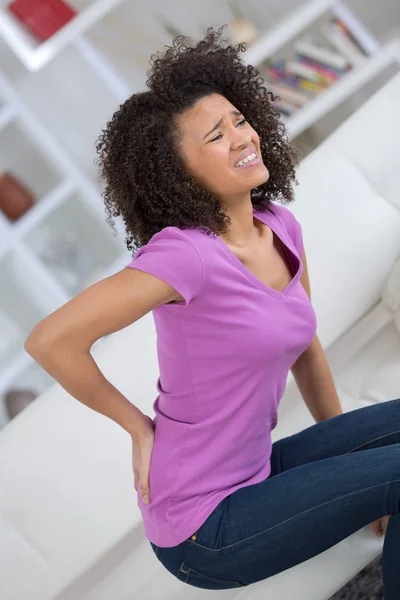 Attraktive Frau mit Rückenschmerzen zu Hause — Stockfoto