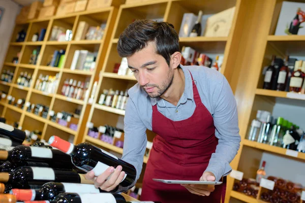 Giovane sommelier con in mano una bottiglia di vino — Foto Stock