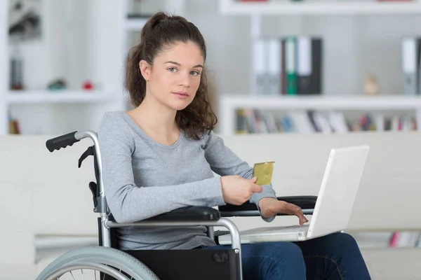 Junge Frau im Rollstuhl benutzt Laptop — Stockfoto