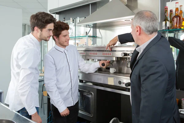 Ägare kafé visar personalen hur man rengör kaffebryggare — Stockfoto