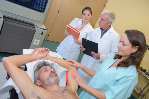Медсестра заспокоює пацієнта руками, піднятими над головою — стокове фото
