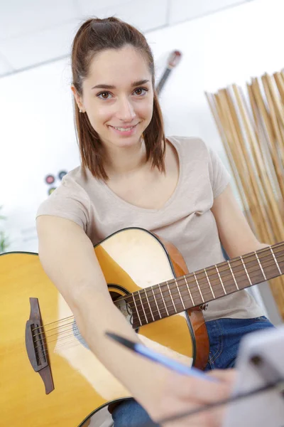 Молода леді з гітарою написання музики — стокове фото