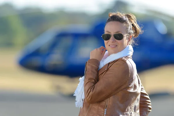 Chica sonriente junto a un helicóptero —  Fotos de Stock