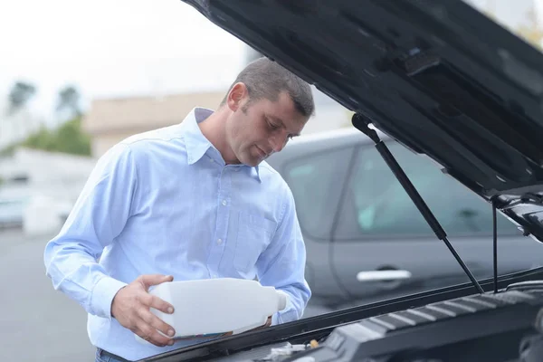 Man filling fresh water into the windscreen wiper system — Stock Photo, Image