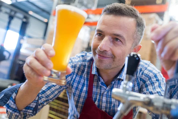 Camarero sirviendo cerveza y hombre — Foto de Stock