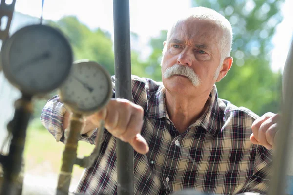 Senior man kontrollera tryckmätare — Stockfoto