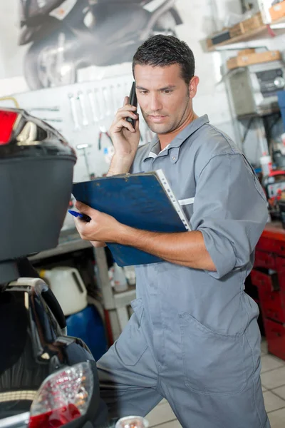 Mekaniker med mobiltelefon och man — Stockfoto