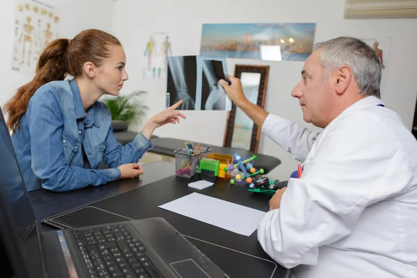 Medico che spiega i raggi X al paziente sorpreso — Foto Stock