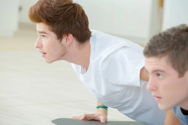 Unga män i Cobra yoga position — Stockfoto