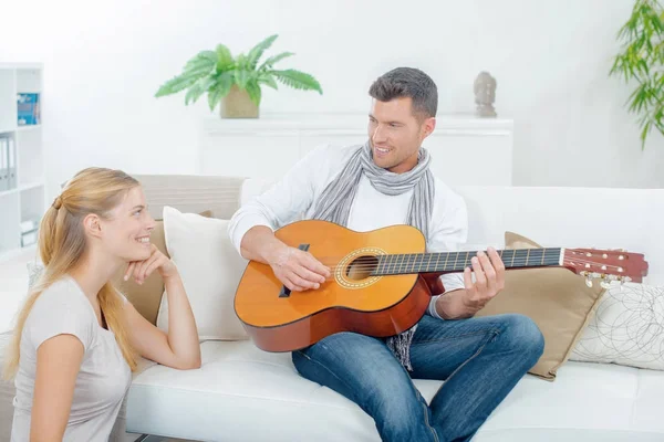 Мужчина играет на гитаре, девушка слушает — стоковое фото
