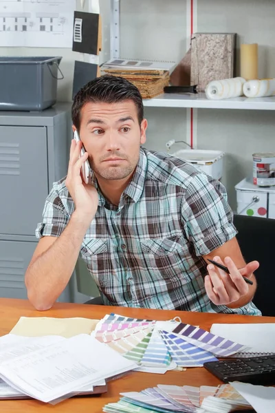 Jeune employé travaillant et téléphonant — Photo