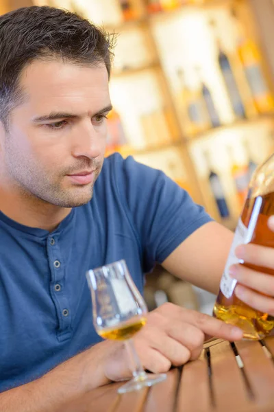 Leitura de um rótulo de licor — Fotografia de Stock