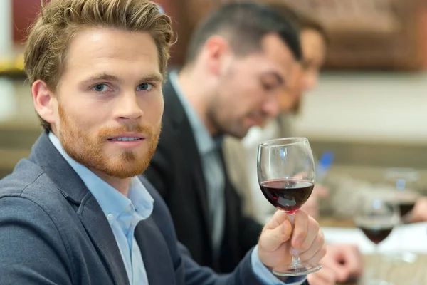 Όμορφος επιχειρηματίας κρατώντας ένα ποτήρι κρασί στο εστιατόριο — Φωτογραφία Αρχείου