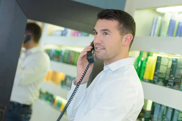 Stilig hairdesser receptionist på telefonen med klienten — Stockfoto
