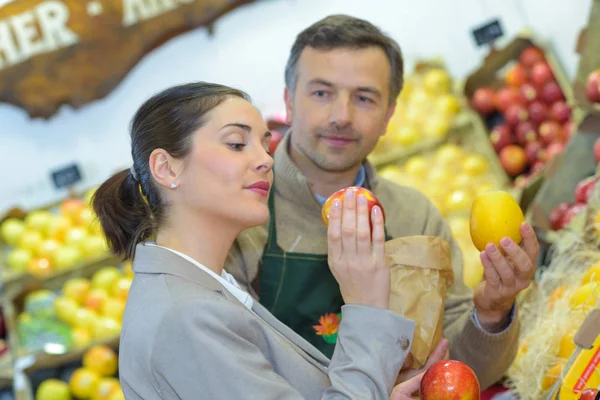 Cliente que inspeciona maçã e cliente — Fotografia de Stock