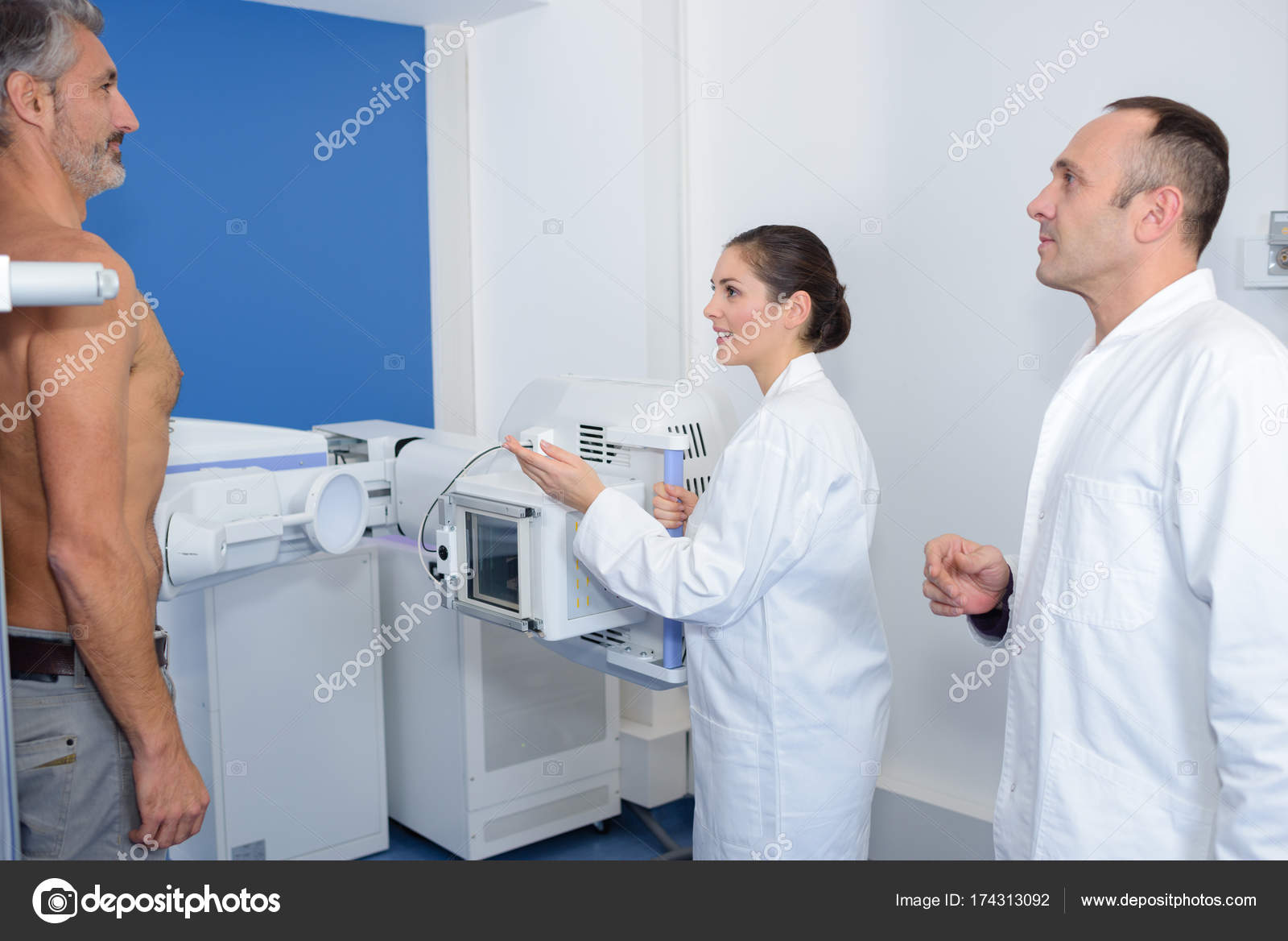 Doctors taking upright xray of mans abdomen Stock Photo by