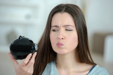 woman looking at piggy bank clipart