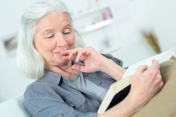 Контент стара леді читає книгу вдома — стокове фото