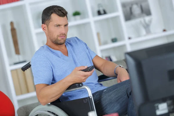 Unga handikappade mannen med fjärrkontrollen — Stockfoto
