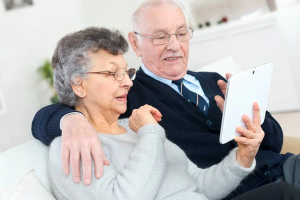 Feliz pareja de ancianos con tablet PC en casa — Foto de Stock