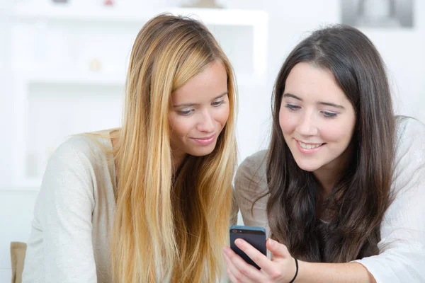 Meninas adolescentes lendo mensagem de texto no telefone móvel — Fotografia de Stock