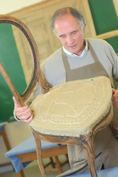 Homme tapissier chaise dans son atelier — Photo