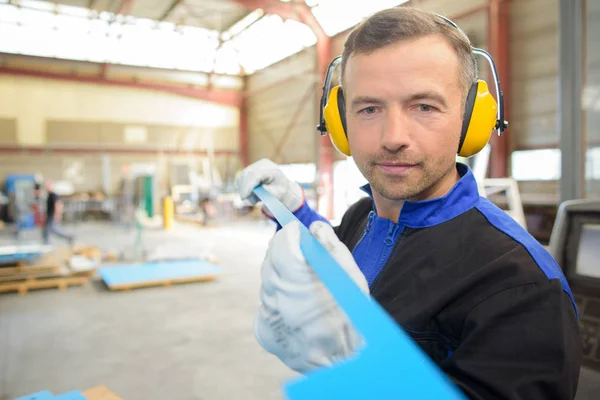 Workman holding formad bit metall — Stockfoto