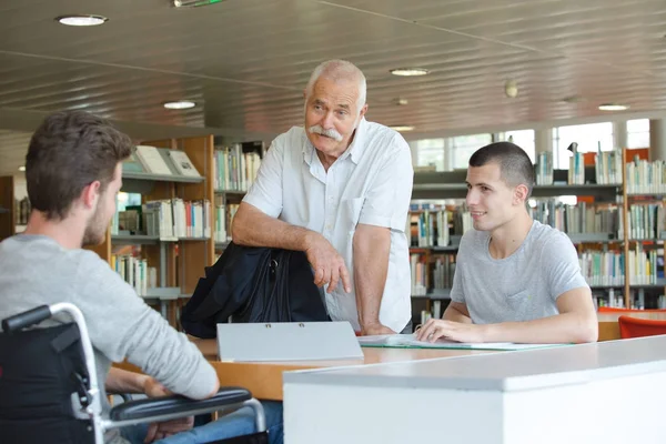 Studenten en leraar in de bibliotheek — Stockfoto