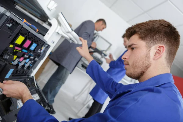 Gros plan jeune technicien masculin réparer photocopieuse numérique — Photo