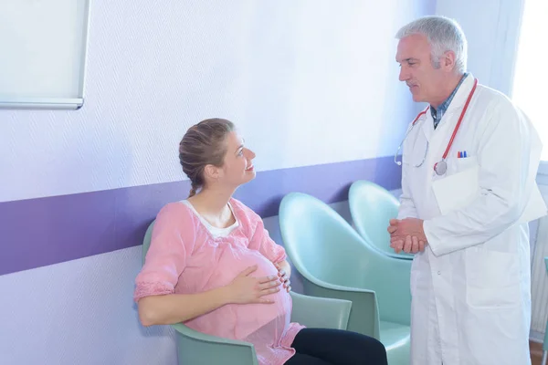 임신한 여 자가 병원 복도에서 의사와 얘기를 웃 고 — 스톡 사진