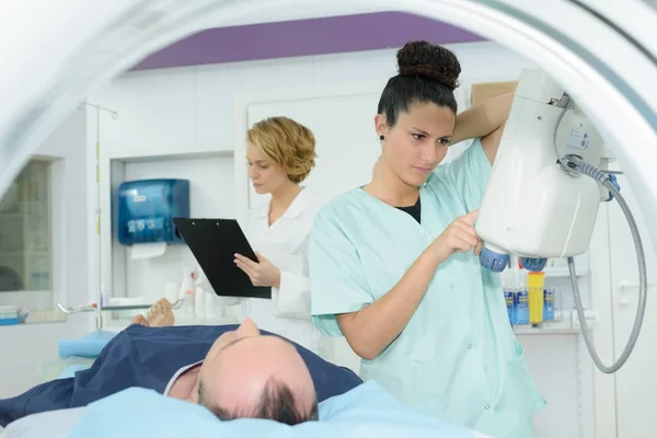 Técnico radiológico y enfermero preparando la resonancia magnética para el paciente masculino — Foto de Stock