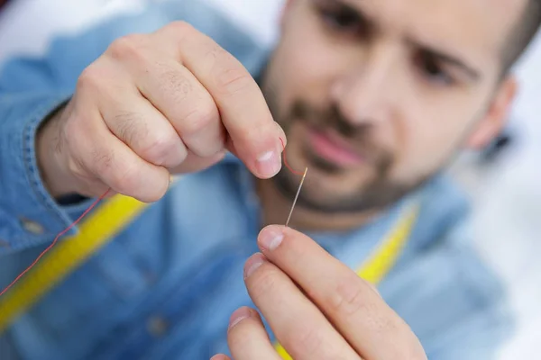 Closeup of tailor threading needle — Stock Photo, Image