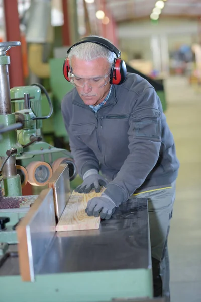 Ανώτερος άνθρωπος χρησιμοποιώντας το μηχάνημα επεξεργασίας ξύλου — Φωτογραφία Αρχείου