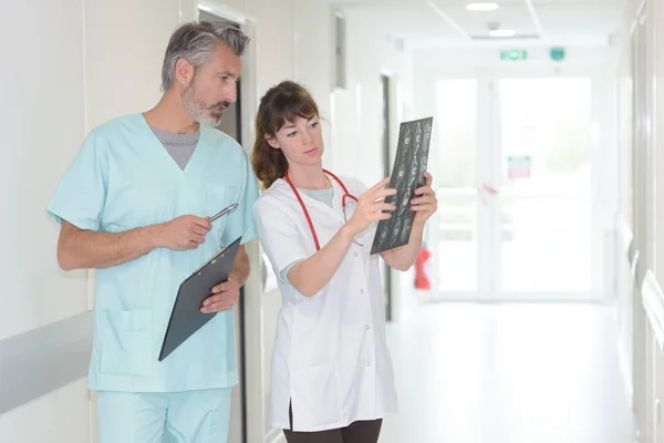 Läkare pekar något ute på en röntgenbild — Stockfoto