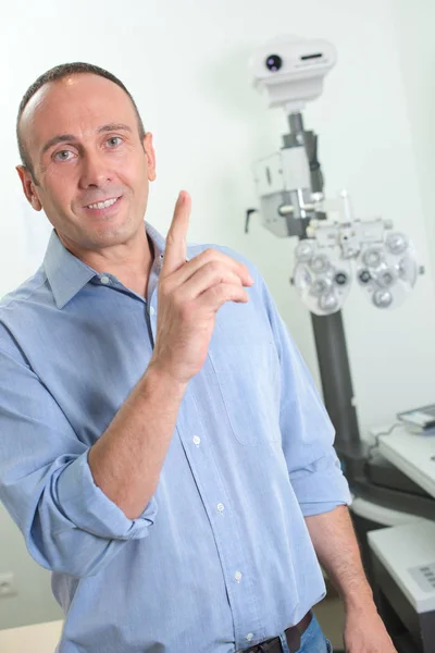 Homme dans les opticiens, pointant du doigt — Photo