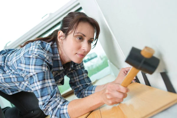 Mujer usando un martillo para bricolaje en casa — Foto de Stock