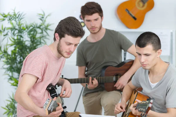 Happy friends playing guitarat home — Stock Photo, Image